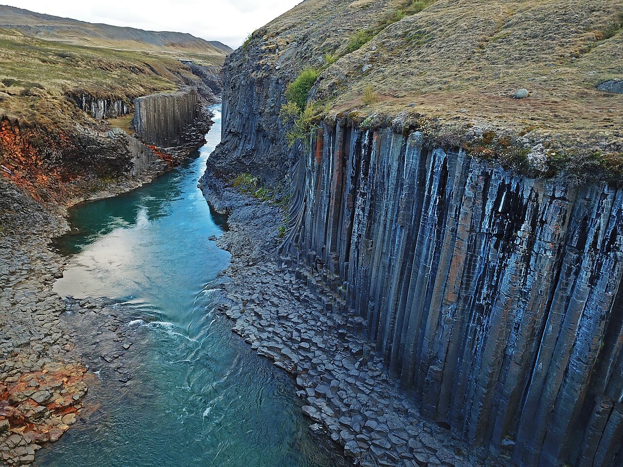 Basalt columns rising above the river at Stuðlagil Canyon