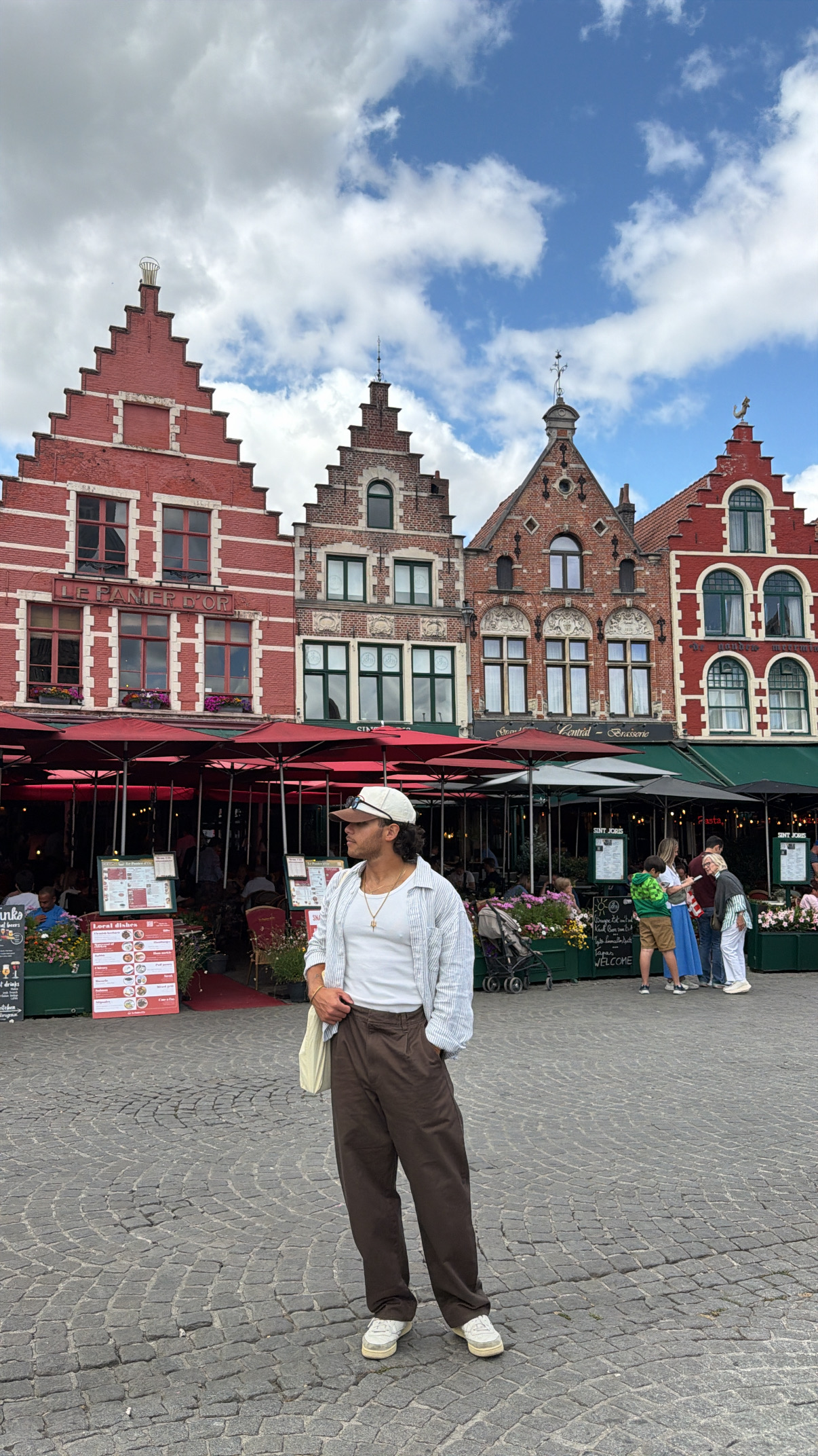 Sebastian standing in a historic city square in front of brick buildings